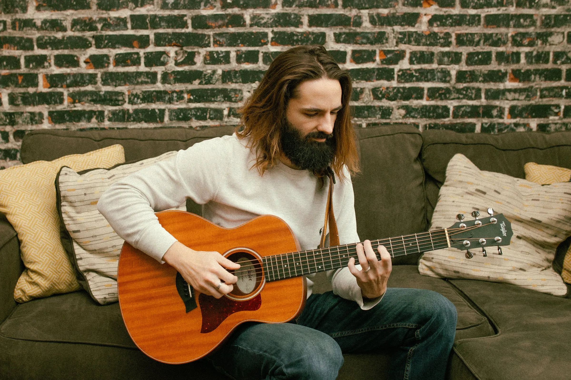 Borin playing guitar on a couch